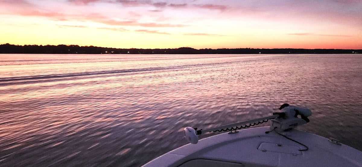 Sunrise over the lake from the bow of a boat, trolling motor up